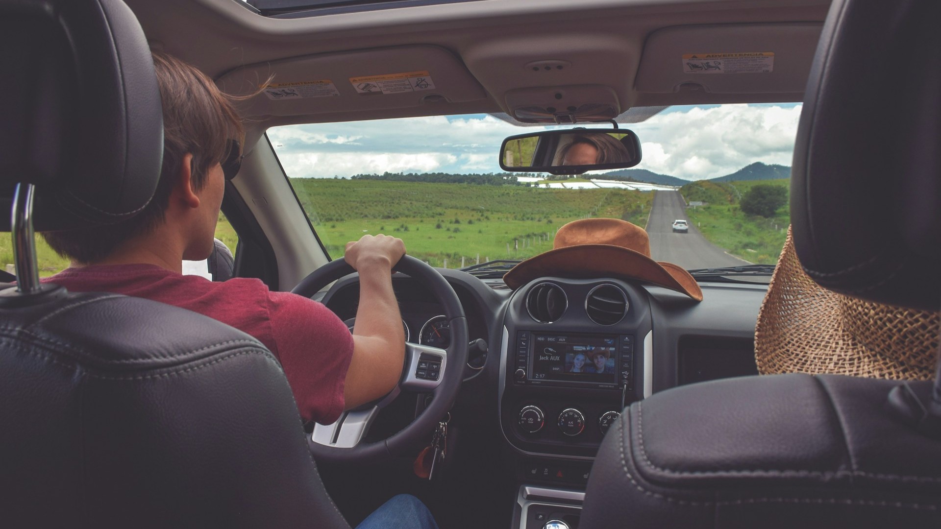 Bestuurder rijdt ontspannen bij mild weer, waarbij temperatuur invloed heeft op rijgedrag, concentratie en rijcomfort